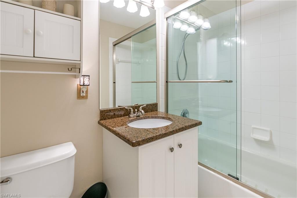 4680 Hawks Nest Way, Unit D103 Naples, FL 34114 - Photo 12 of 35 a bathroom with a granite countertop sink and a mirror
