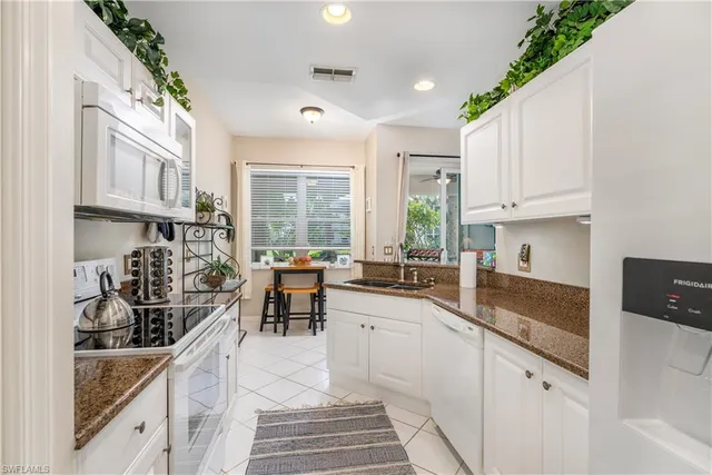a kitchen with sink a stove and cabinets