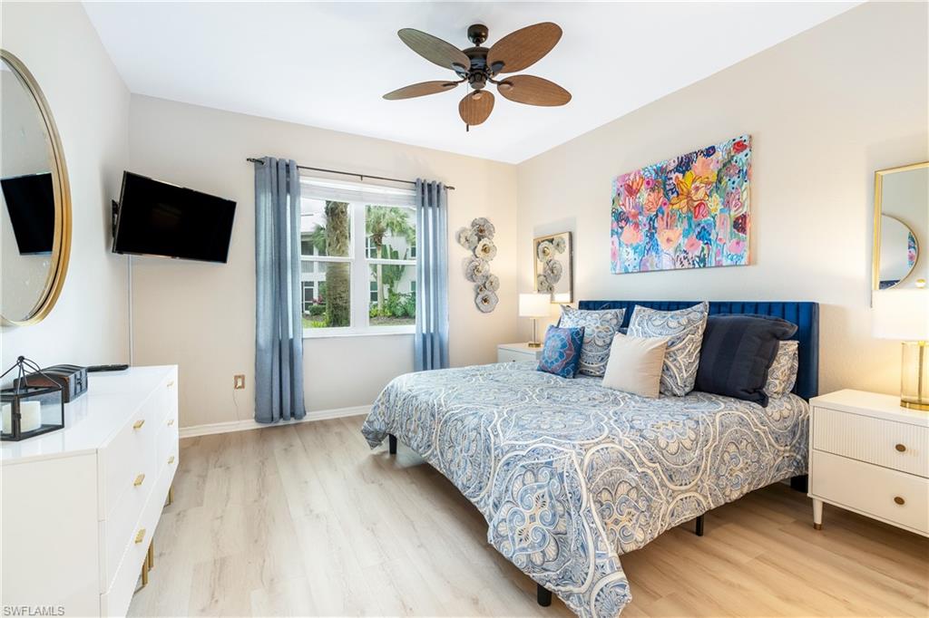 4680 Hawks Nest Way, Unit D103 Naples, FL 34114 - Photo 5 of 35 a spacious bedroom with a bed and a flat screen tv