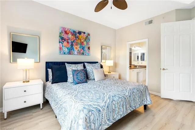 a bedroom with a large bed and a chandelier