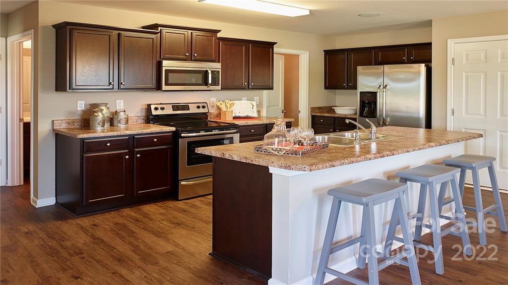 304 Gaines Road Clover, SC 29710 - Photo 35 of 48 a kitchen with kitchen island granite countertop wooden cabinets a stove top oven a sink and dishwasher