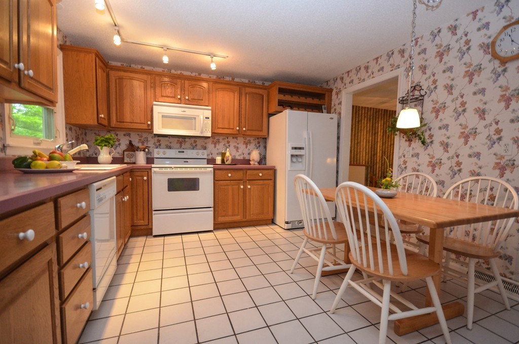 211 Mason Road Northbridge, MA 01588 - Photo 8 of 25 a kitchen with stainless steel appliances granite countertop a stove top oven a sink a dining table and chairs