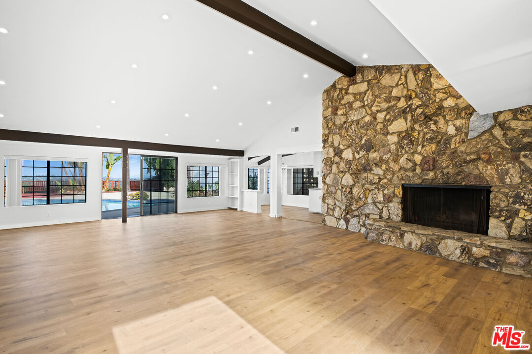 a view of empty room with wooden floor and fireplace