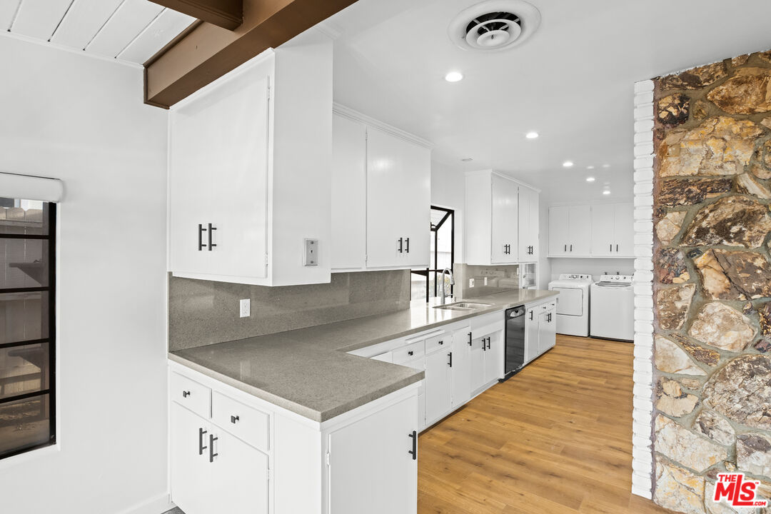2254 Stradella Road Los Angeles, CA 90077 - Photo 12 of 27 a kitchen with granite countertop a sink stainless steel appliances and white cabinets