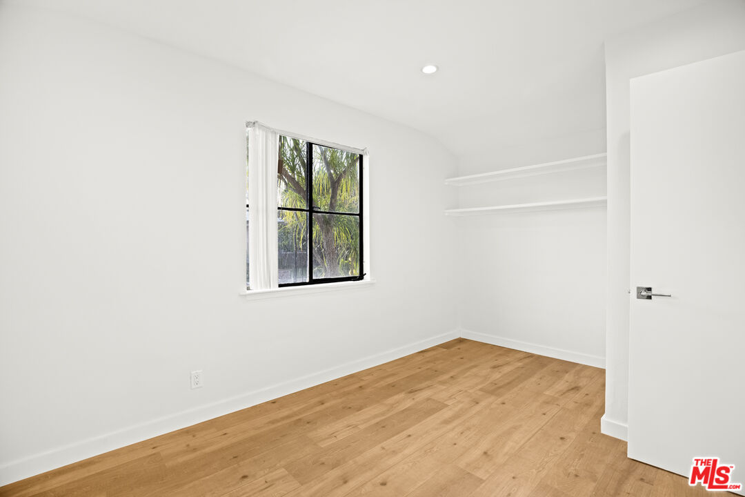 2254 Stradella Road Los Angeles, CA 90077 - Photo 16 of 27 a view of an empty room with wooden floor and a window