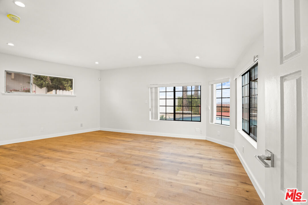 2254 Stradella Road Los Angeles, CA 90077 - Photo 18 of 27 a view of an empty room with a window and wooden floor