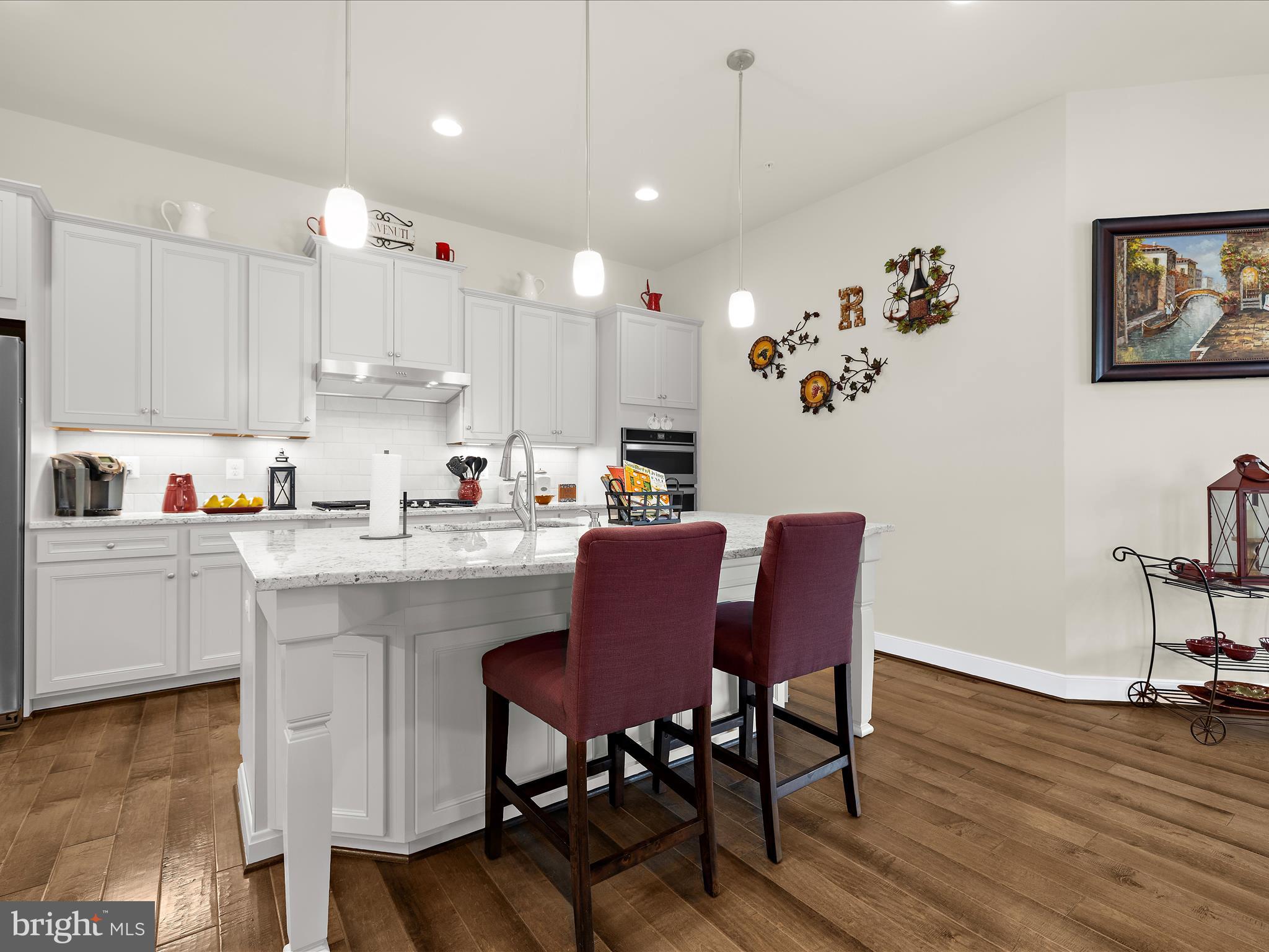 1530 Yellow Sand Lane Odenton, MD 21113 - Photo 15 of 87 a kitchen with kitchen island a dining table chairs cabinets and a counter top space