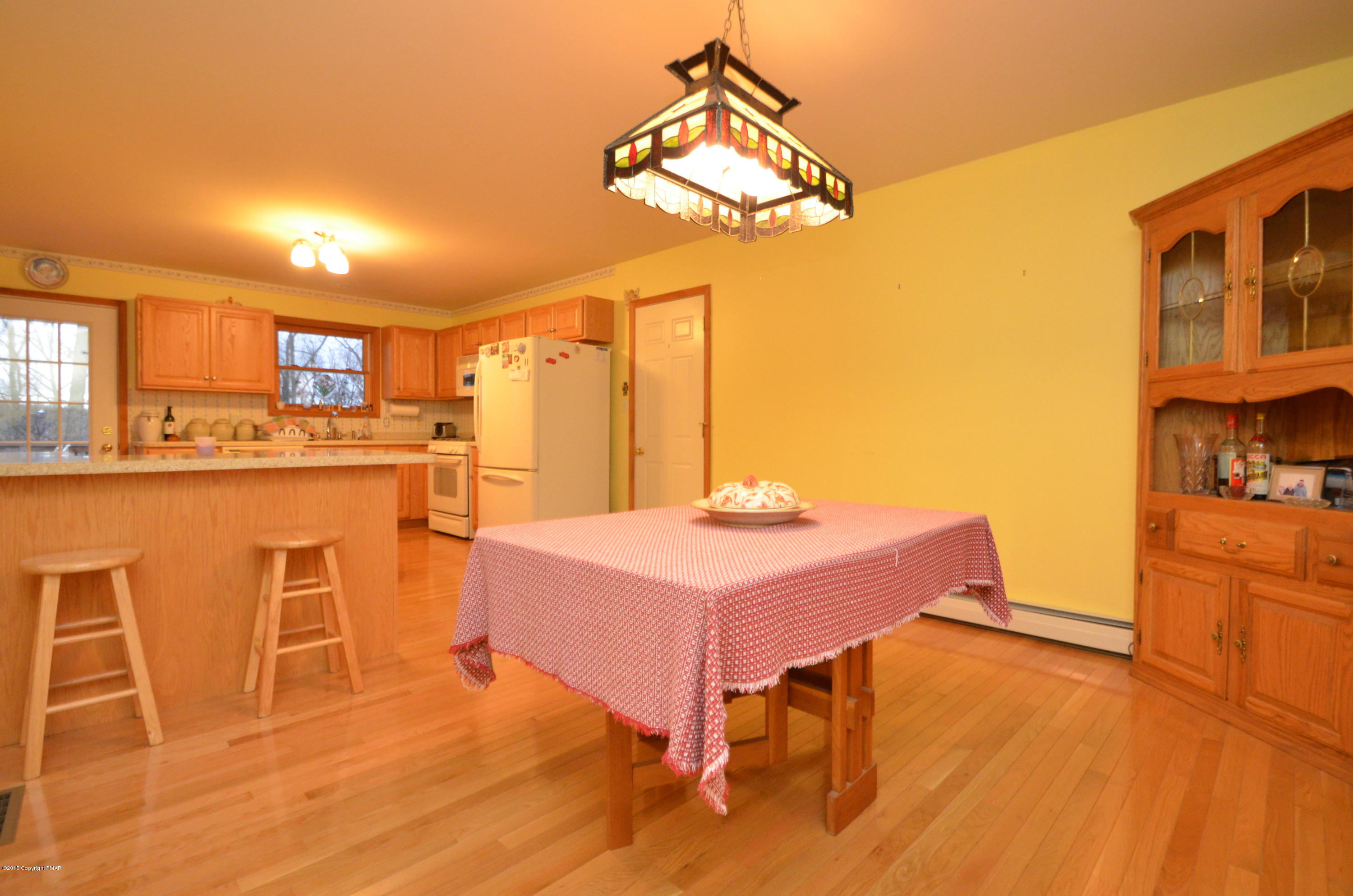 699 Buckle Boot Road Henryville, PA 18332 - Photo 3 of 26 a kitchen with a table chairs refrigerator and cabinets