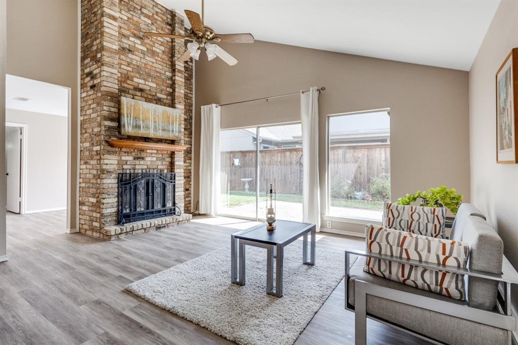 9547 Highland View Drive Dallas, TX 75238 - Photo 7 of 19 Living room with light wood-type flooring, ceiling fan, brick fireplace, and vaulted ceiling