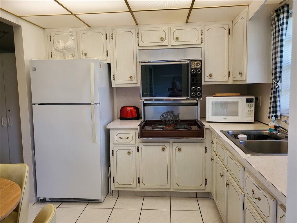 5300 Washington Street, Unit H136 Hollywood, FL 33021 - Photo 12 of 38 a kitchen with cabinets a refrigerator and a stove