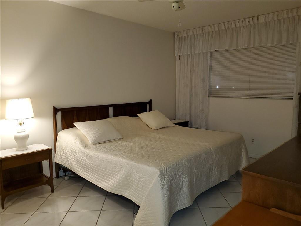 5300 Washington Street, Unit H136 Hollywood, FL 33021 - Photo 16 of 38 a bedroom with a bed and a lamp
