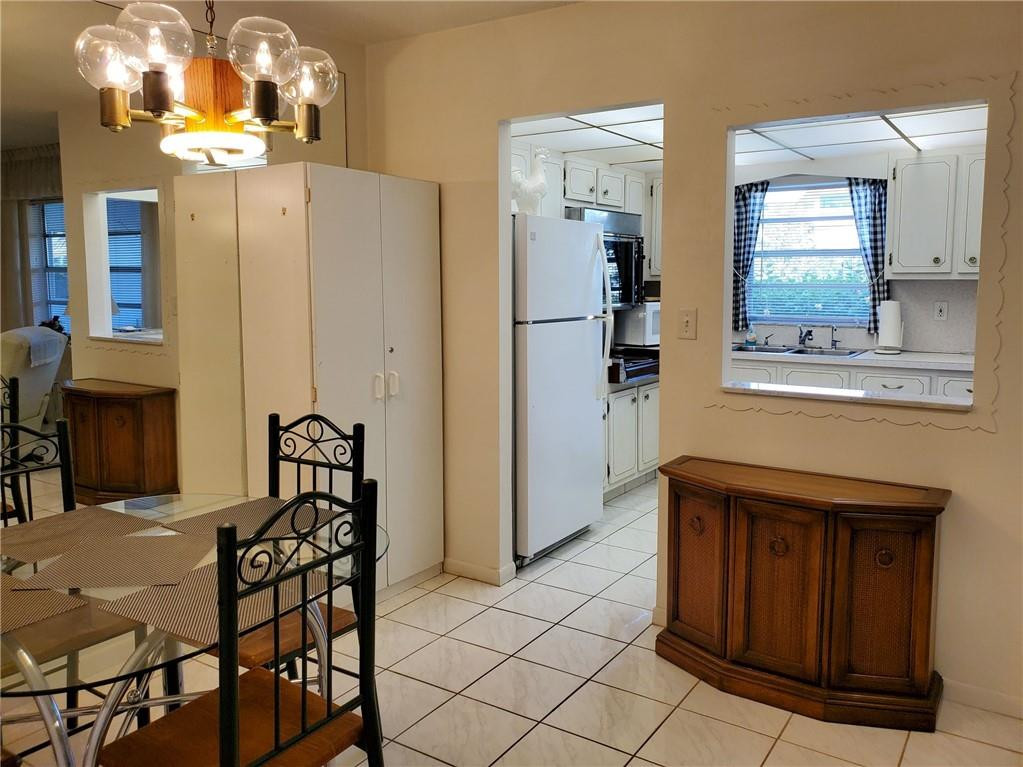 5300 Washington Street, Unit H136 Hollywood, FL 33021 - Photo 10 of 38 a dining room with wooden floor and chandelier