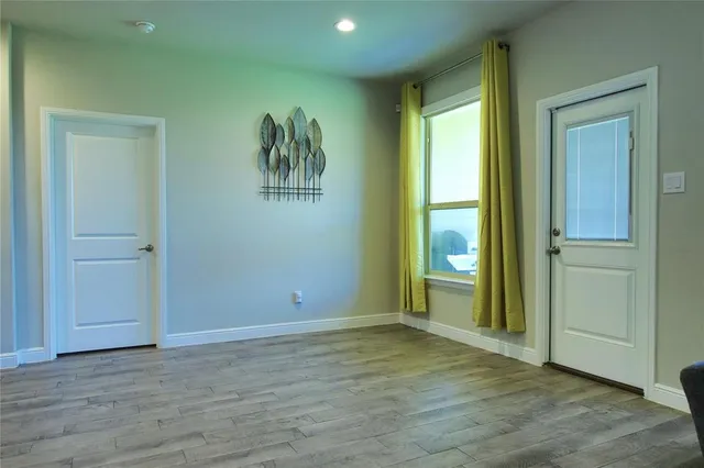 an empty room with wooden floor and window