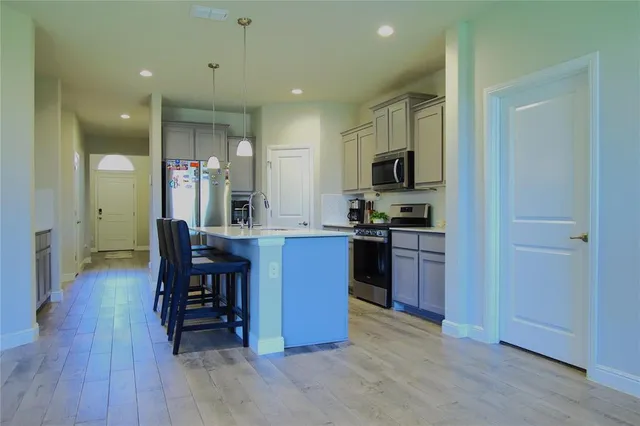 a kitchen with stainless steel appliances kitchen island granite countertop a refrigerator and a stove top oven