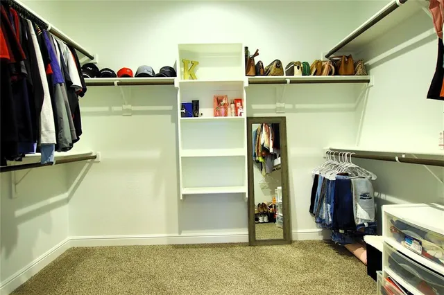 a view of walk in closet with clothes and shoes