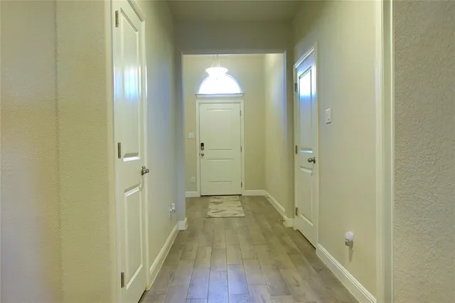 a view of a hallway with wooden floor