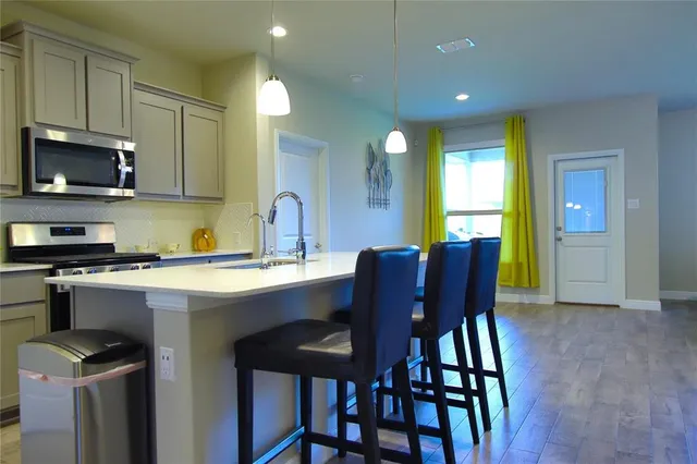 a kitchen with a table chairs sink and microwave