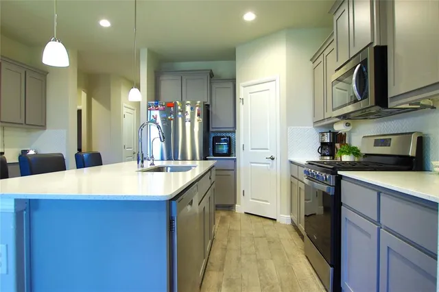 a kitchen with stainless steel appliances granite countertop a sink and a refrigerator