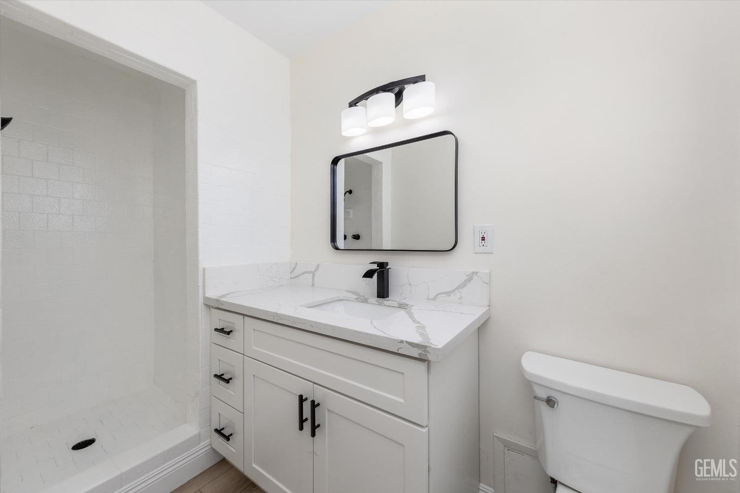 Undisclosed Address Bakersfield, CA 93312 - Photo 17 of 23 a bathroom with a toilet sink vanity and mirror