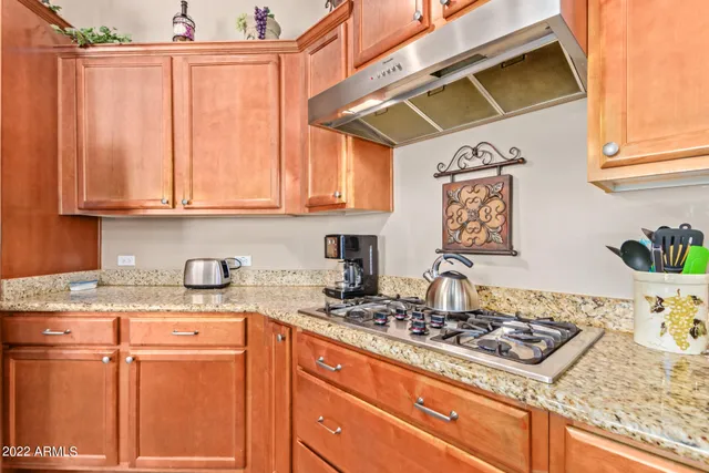 a kitchen with stainless steel appliances granite countertop a stove a sink dishwasher and cabinets with wooden floor