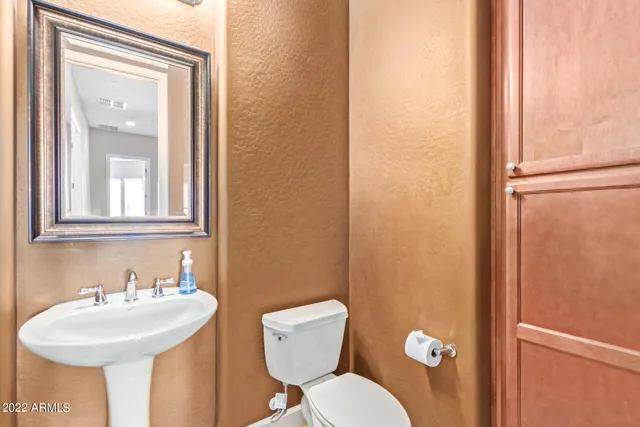 a bathroom with a sink mirror and toilet