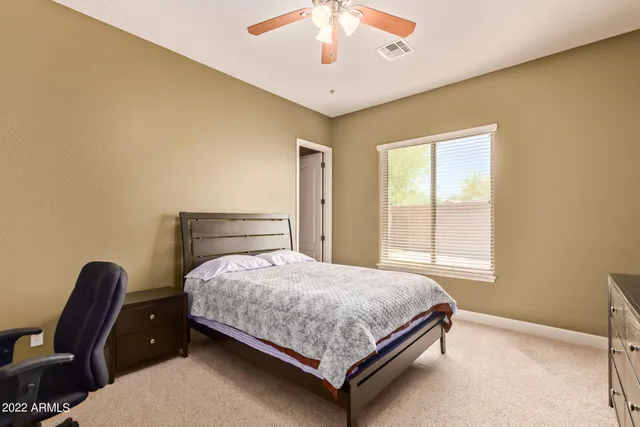 a bedroom with a bed chair and a window