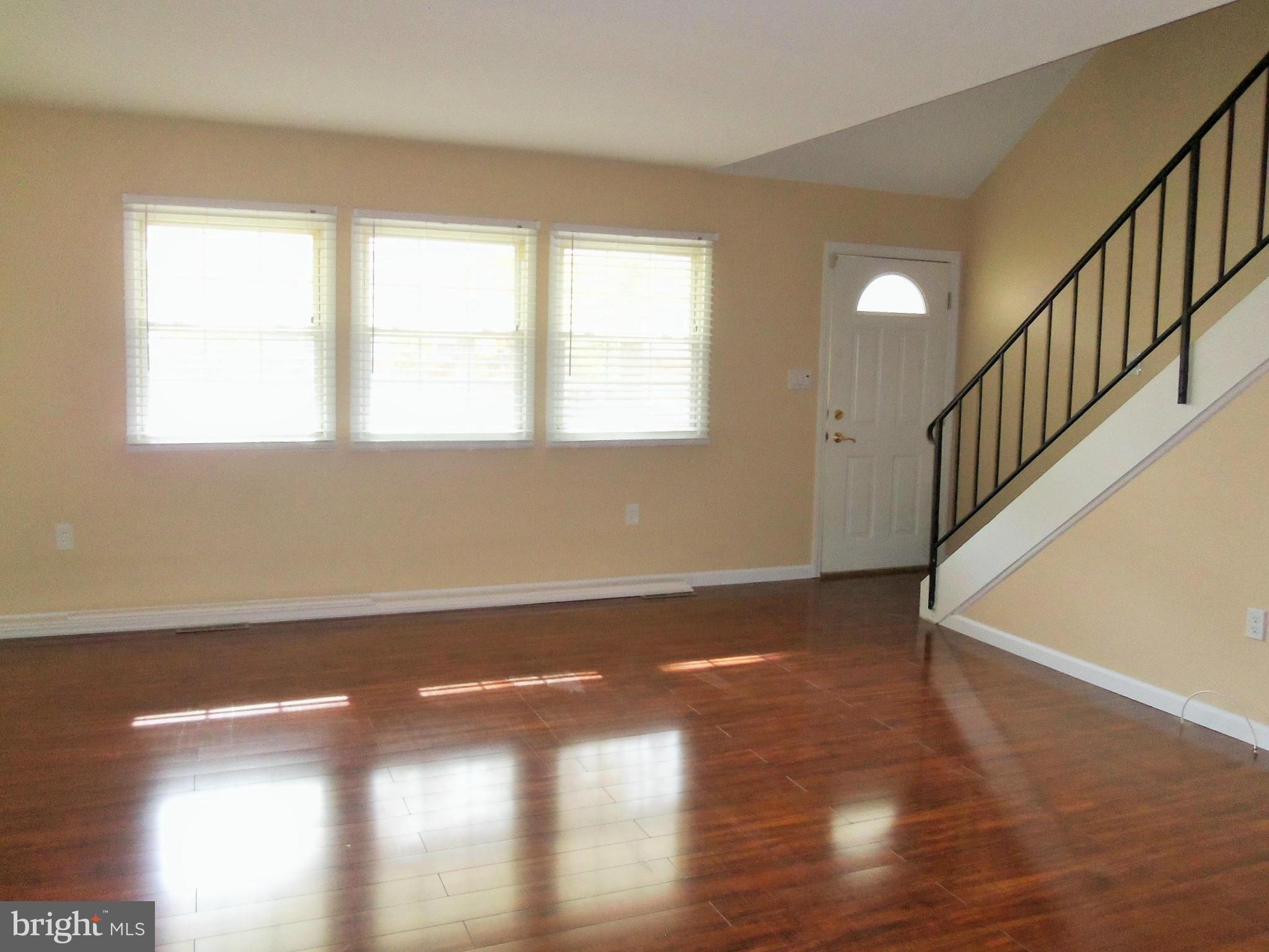 1920 Brookdale Road Baltimore, MD 21244 - Photo 4 of 22 a view of an empty room with wooden floor and a window