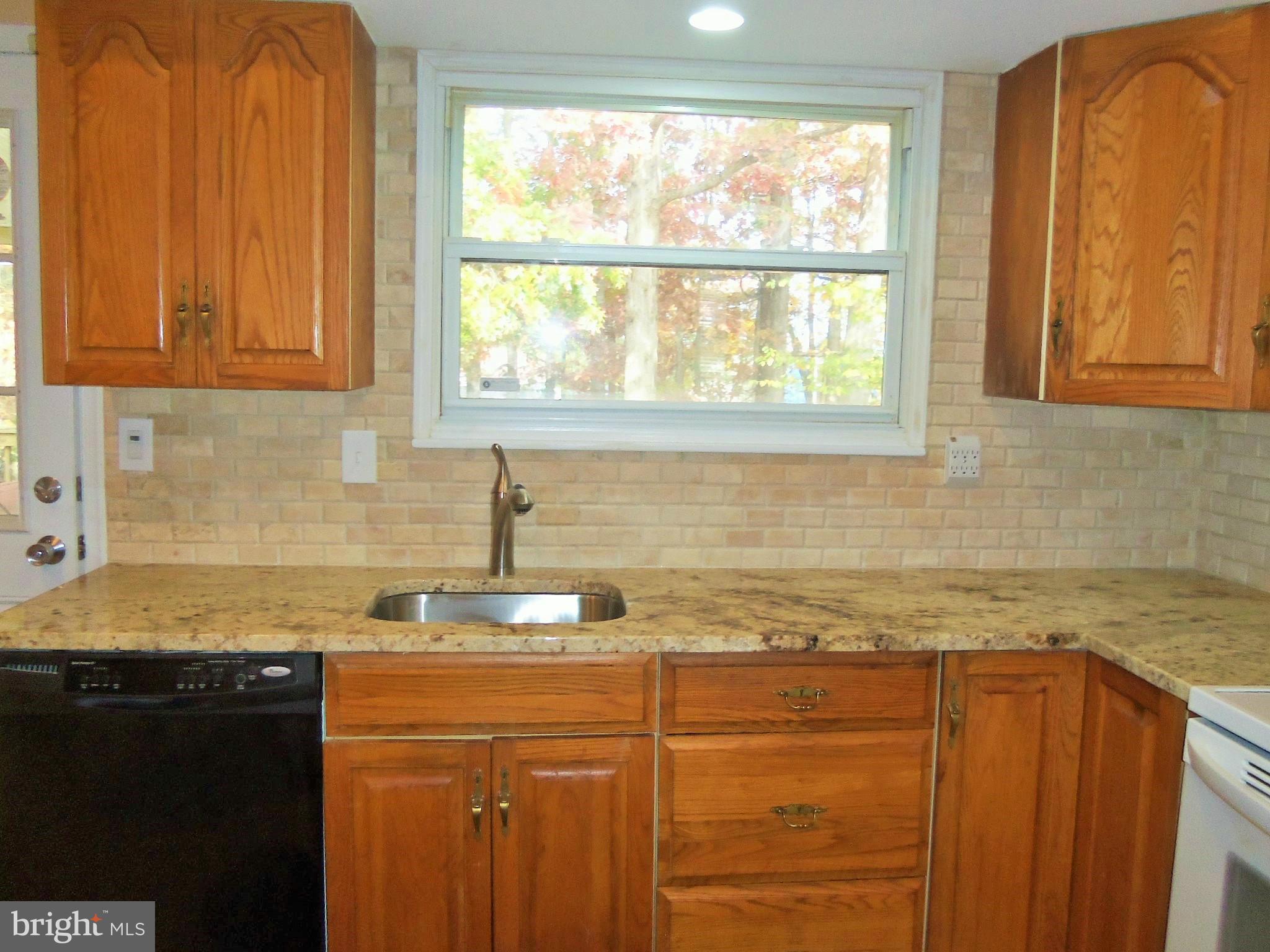 1920 Brookdale Road Baltimore, MD 21244 - Photo 6 of 22 a kitchen with granite countertop cabinets sink and window