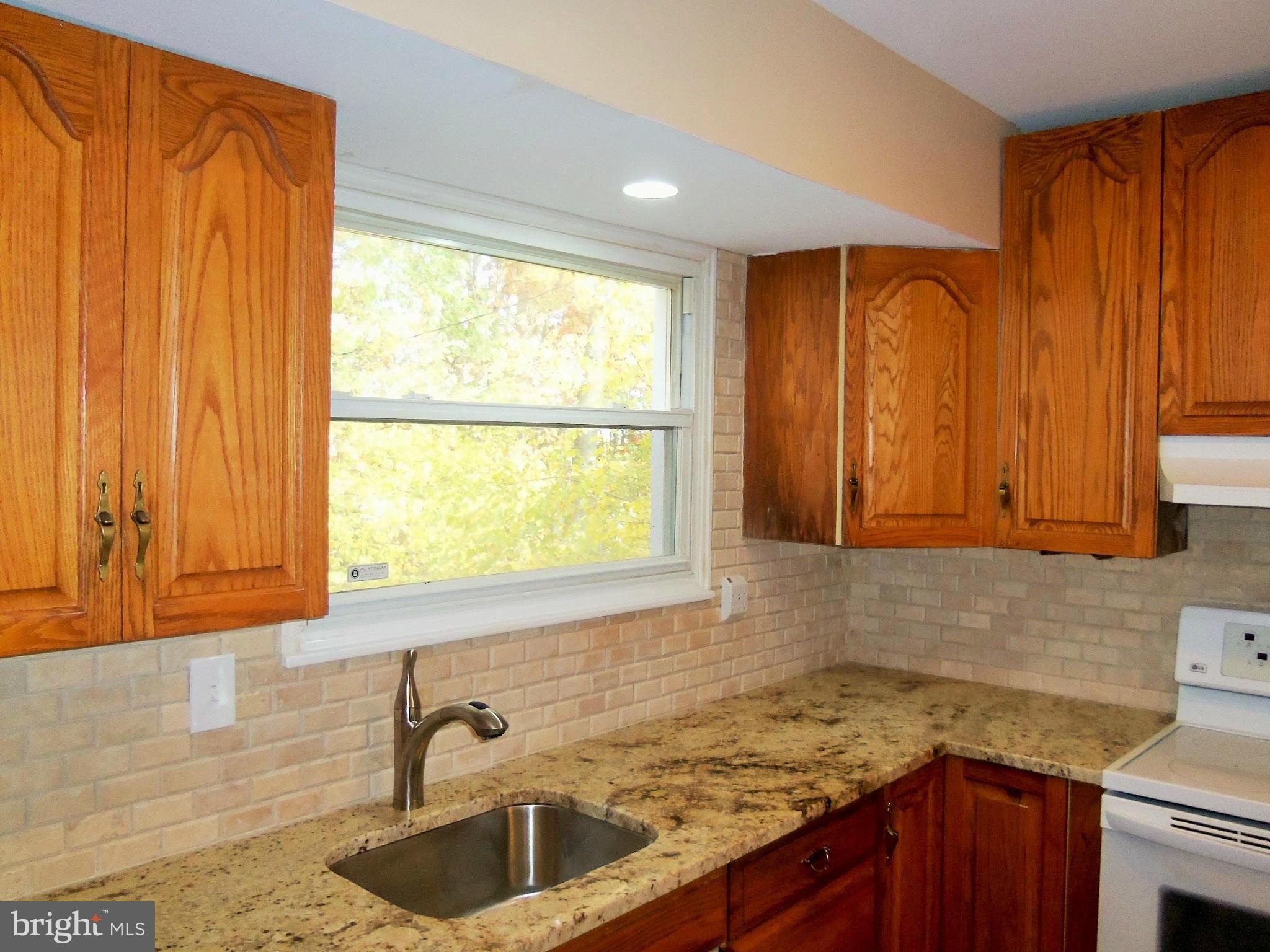 1920 Brookdale Road Baltimore, MD 21244 - Photo 8 of 22 a kitchen with stainless steel appliances granite countertop a sink window and cabinets