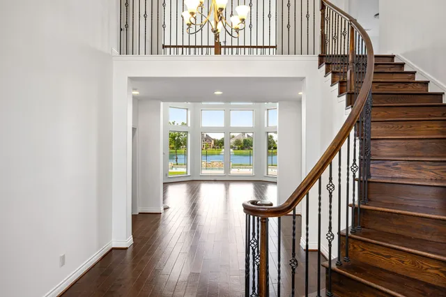 a view of staircase with wooden floor and a large window