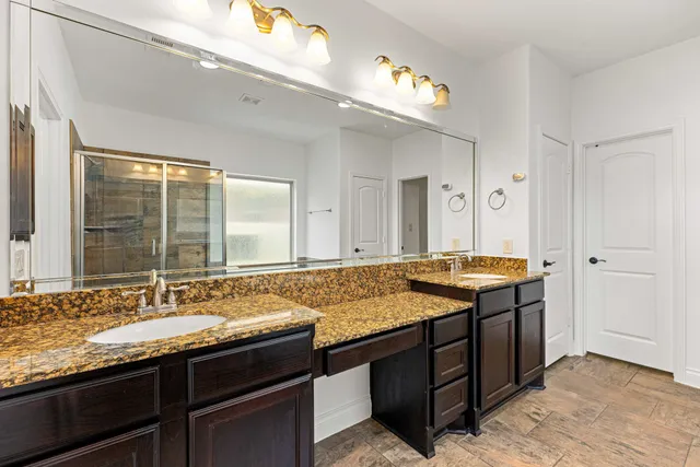a bathroom with a granite countertop sink and a mirror