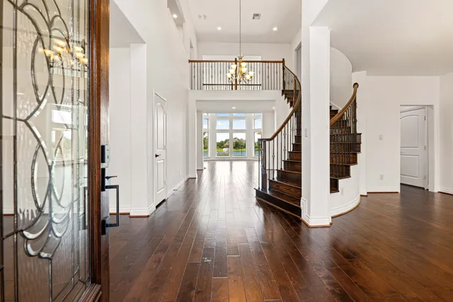 a view of a hallway with wooden floor and staircase