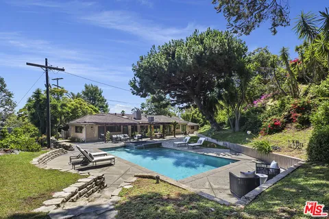 a view of a house with swimming pool and sitting area
