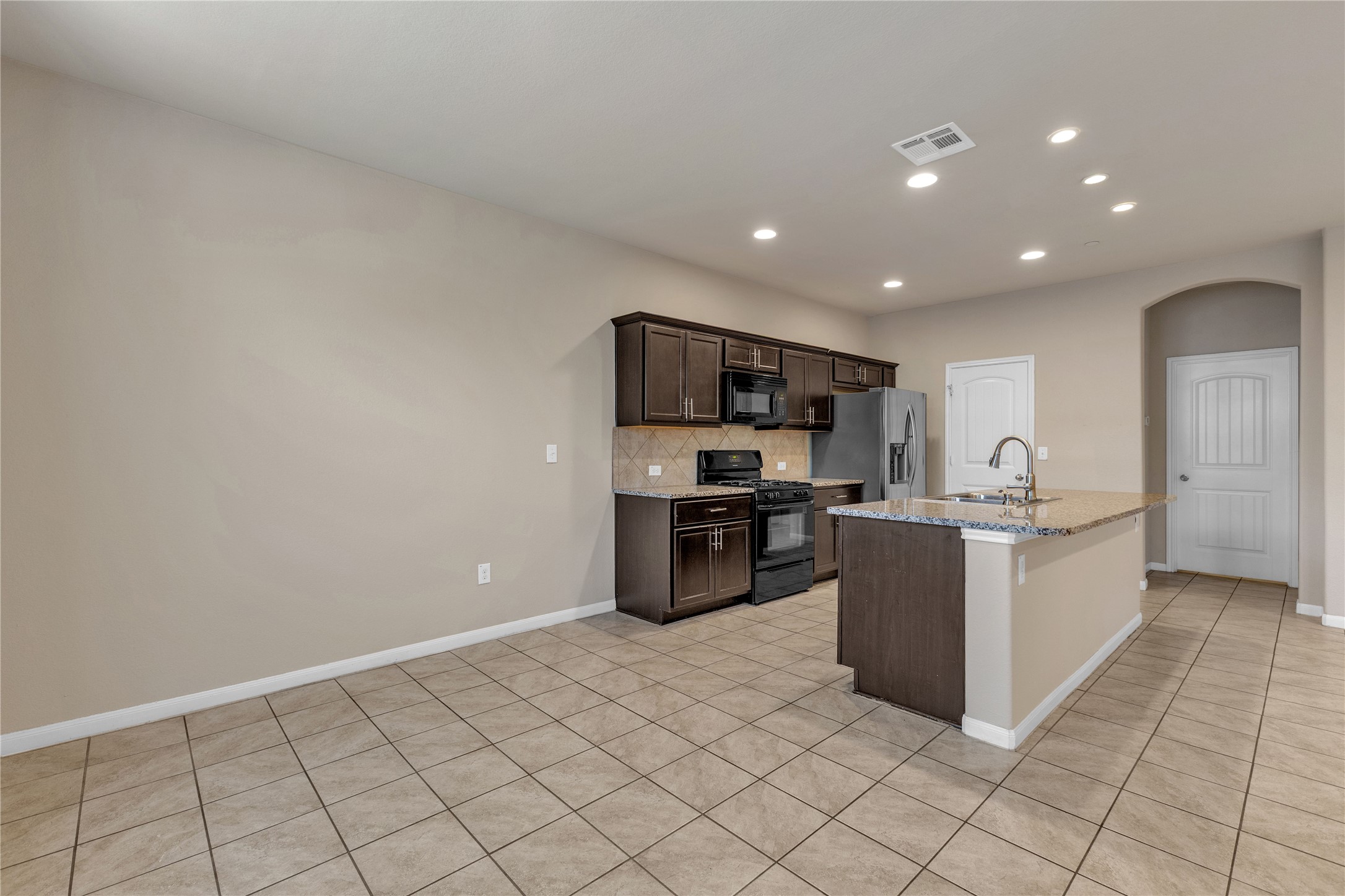 2880 Donnell Drive, Unit 2003 Round Rock, TX 78664 - Photo 14 of 31 Kitchen featuring dark wood-finish cabinetry, granite countertops, and stainless steel appliances