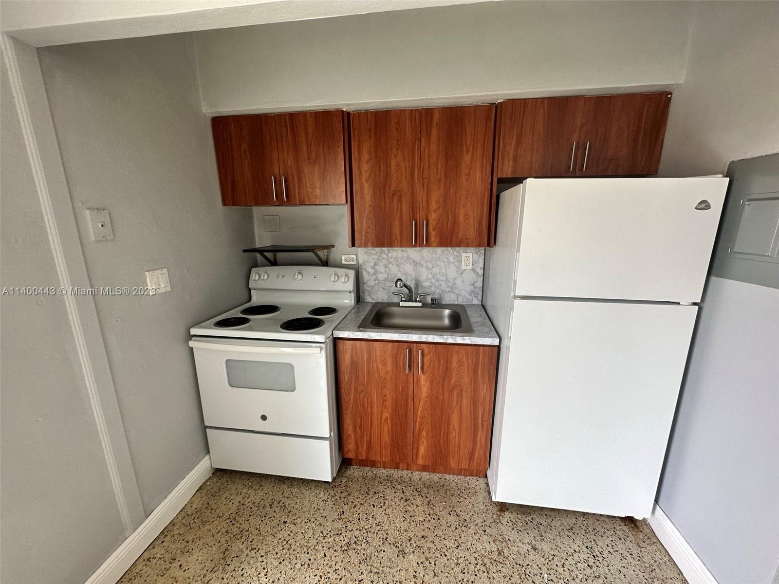 West Flagler Miami, FL 33125 - Photo 7 of 14 a kitchen with a refrigerator sink stove and cabinets