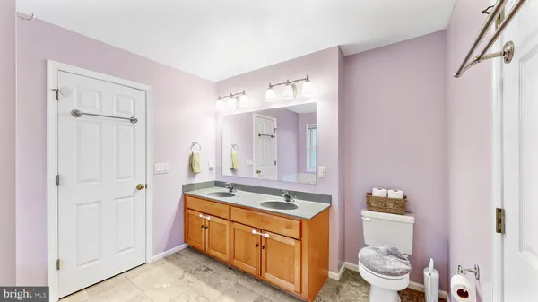 a spacious bathroom with a granite countertop sink a toilet and a mirror