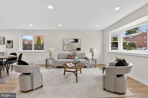 a kitchen with stainless steel appliances granite countertop white cabinets a sink a stove a microwave and wooden floors