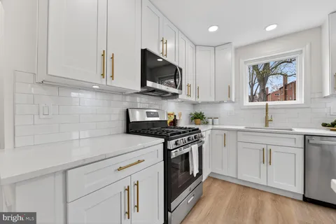 a bathroom with a toilet sink vanity tub and mirror