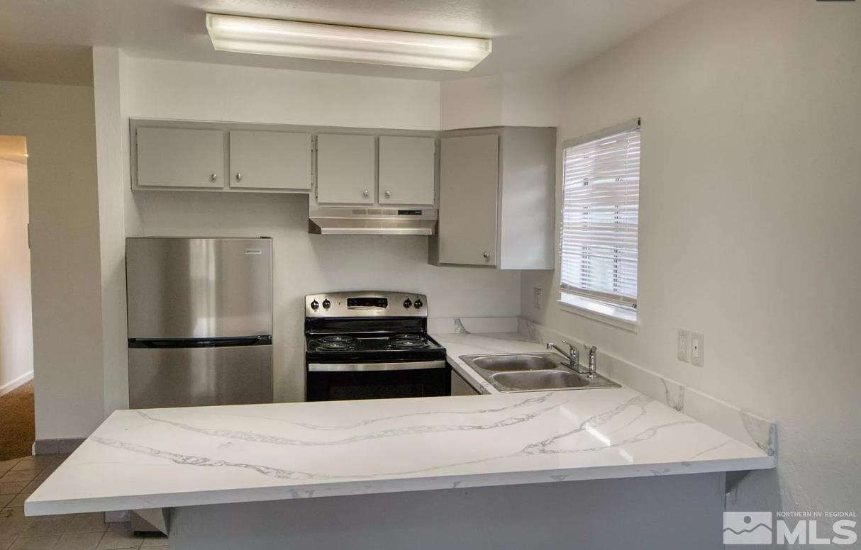 1446 Model Way, Unit 5 Reno, NV 89502 - Photo 3 of 9 a kitchen with a sink appliances and cabinets