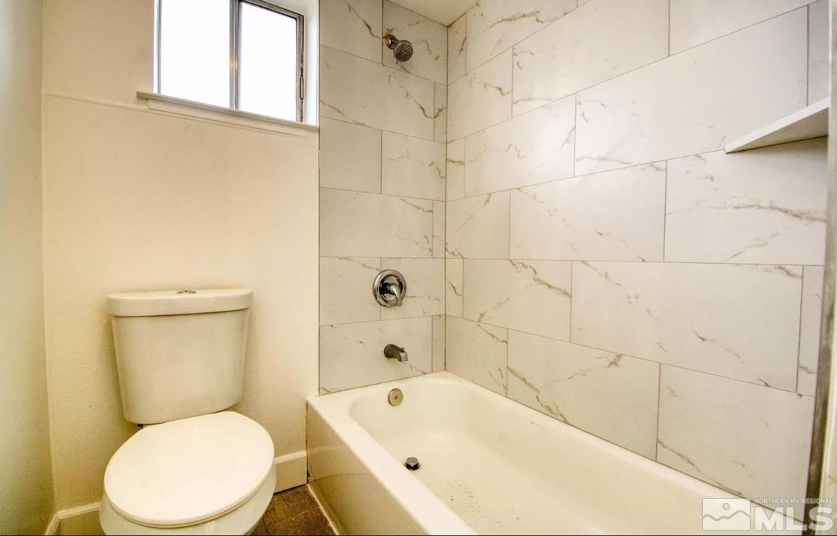 1446 Model Way, Unit 5 Reno, NV 89502 - Photo 8 of 9 a white toilet sitting next to a bath tub and a shower