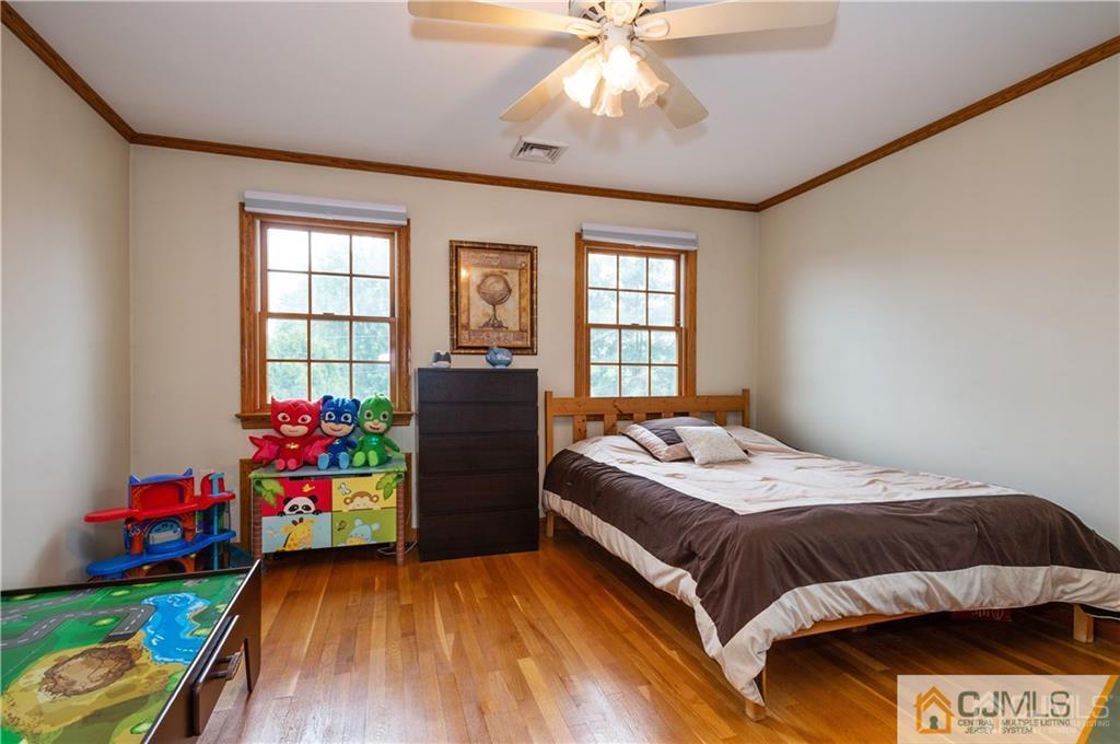 555 Chain O' Hills Road Colonia, NJ 07067 - Photo 13 of 18 a bedroom with a bed and a chandelier