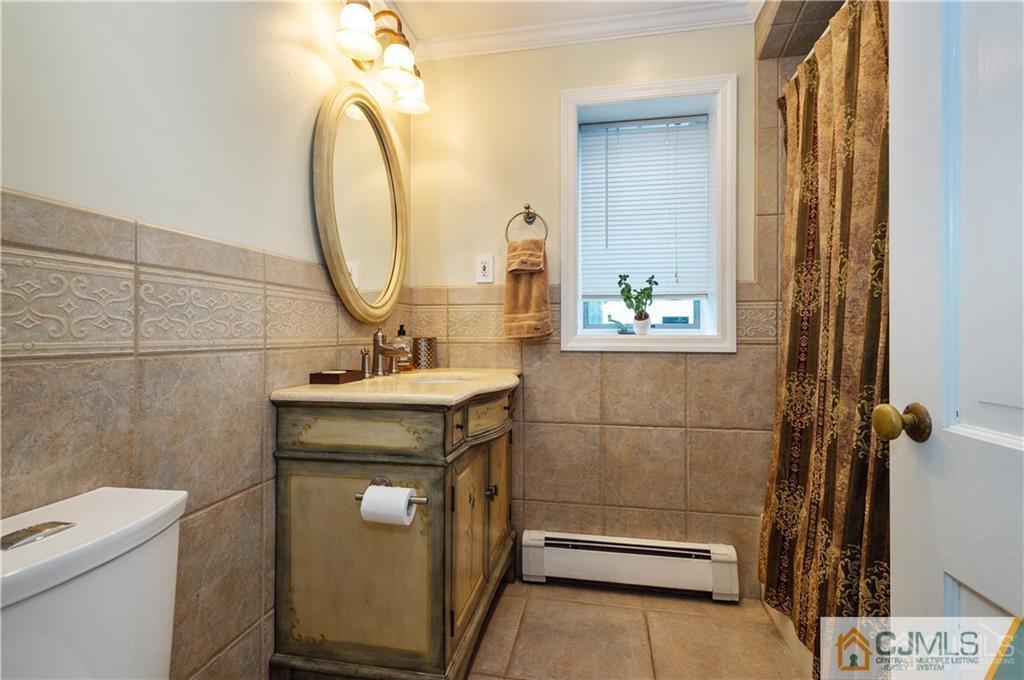 555 Chain O' Hills Road Colonia, NJ 07067 - Photo 15 of 18 a bathroom with a sink a toilet and a mirror