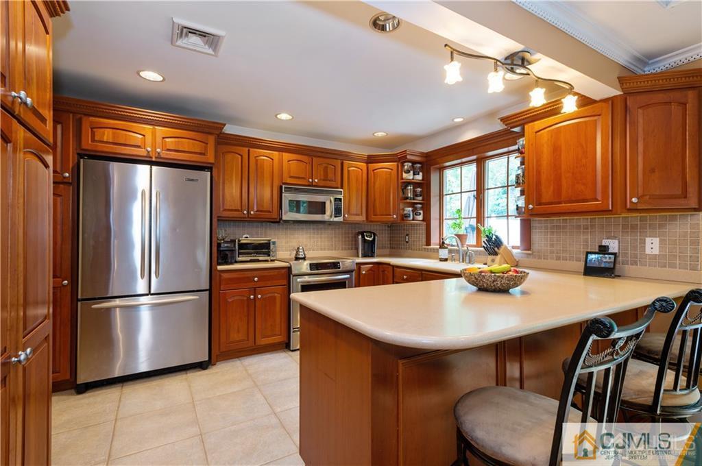 555 Chain O' Hills Road Colonia, NJ 07067 - Photo 6 of 18 a kitchen with stainless steel appliances a refrigerator a sink a stove a table and chairs