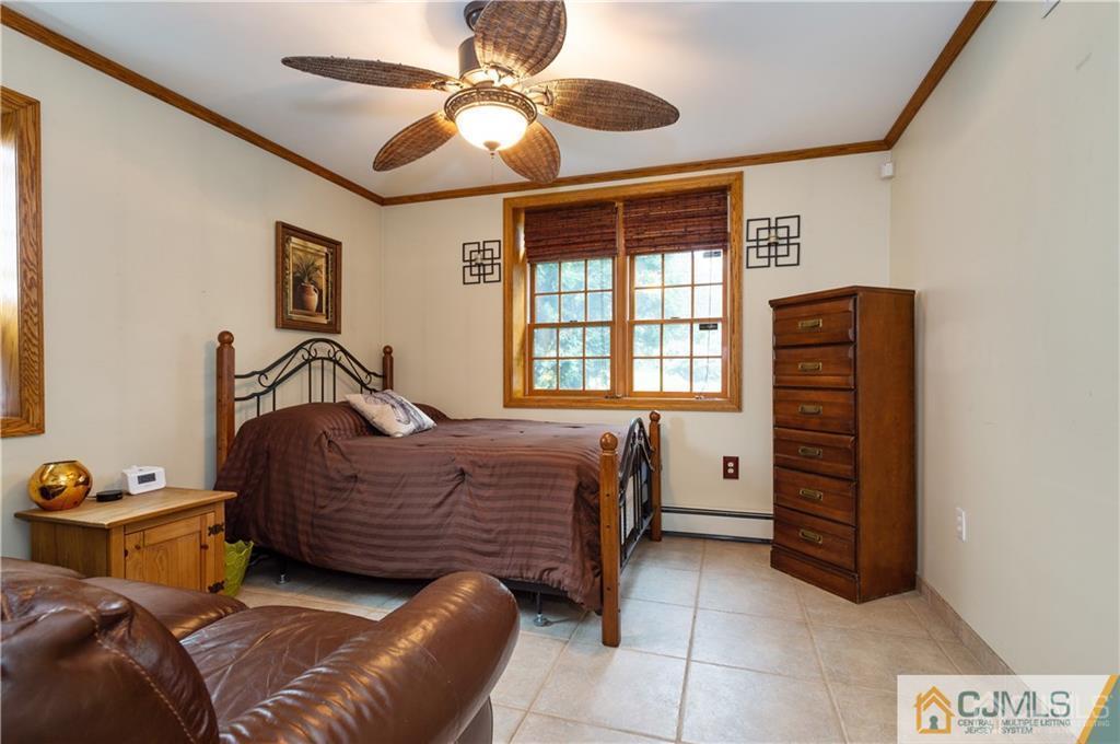555 Chain O' Hills Road Colonia, NJ 07067 - Photo 10 of 18 a bedroom with a bed and a chandelier