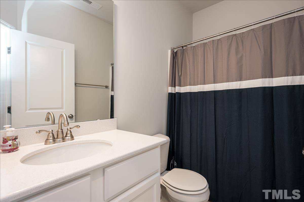 3620 Buffaloe Road Raleigh, NC 27604 - Photo 14 of 18 a bathroom with a sink a toilet a vanity and mirror