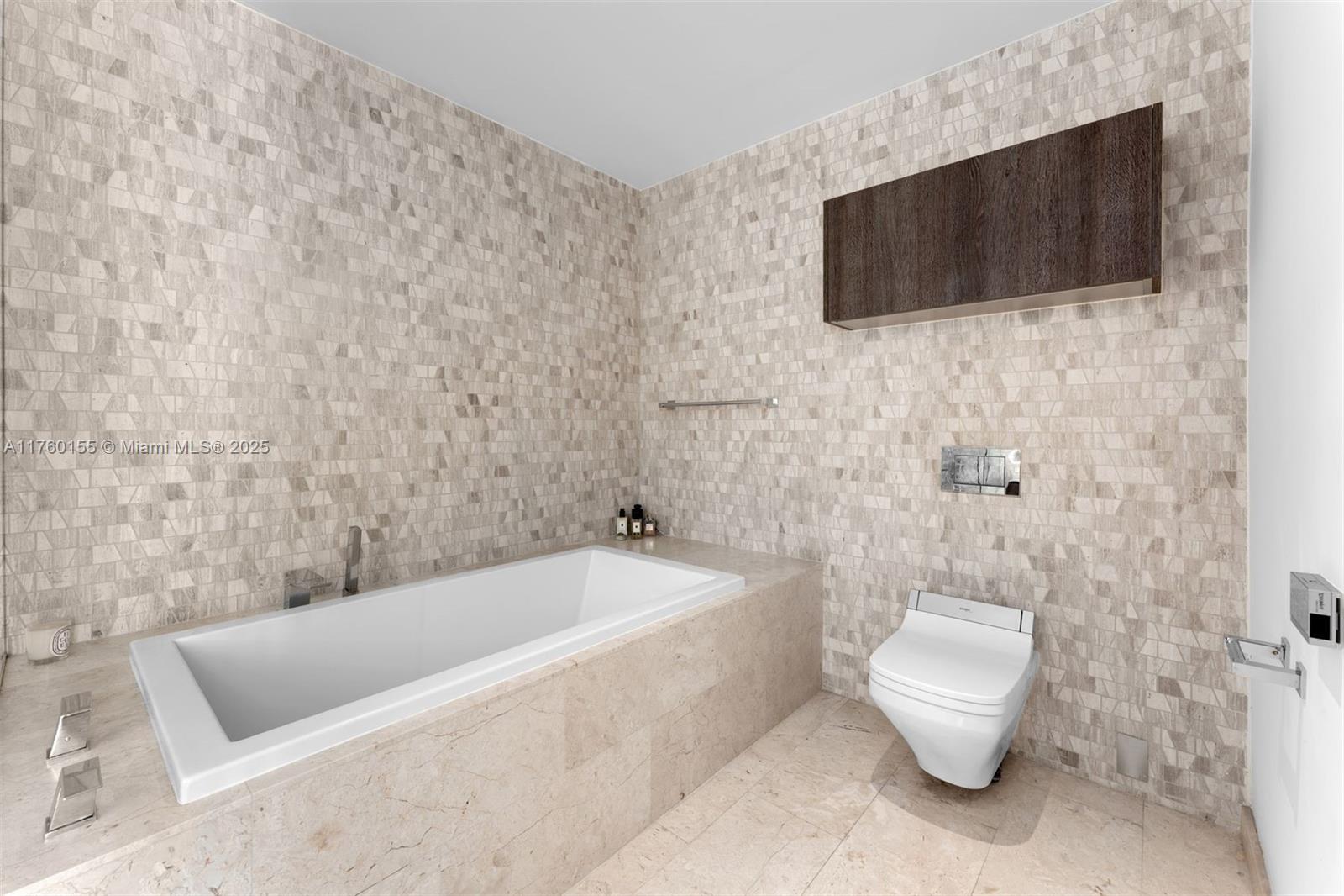 68 Southeast 6th Street, Unit 1404 Miami, FL 33131 - Photo 14 of 26 a bathroom with a toilet a flat screen tv and bathtub