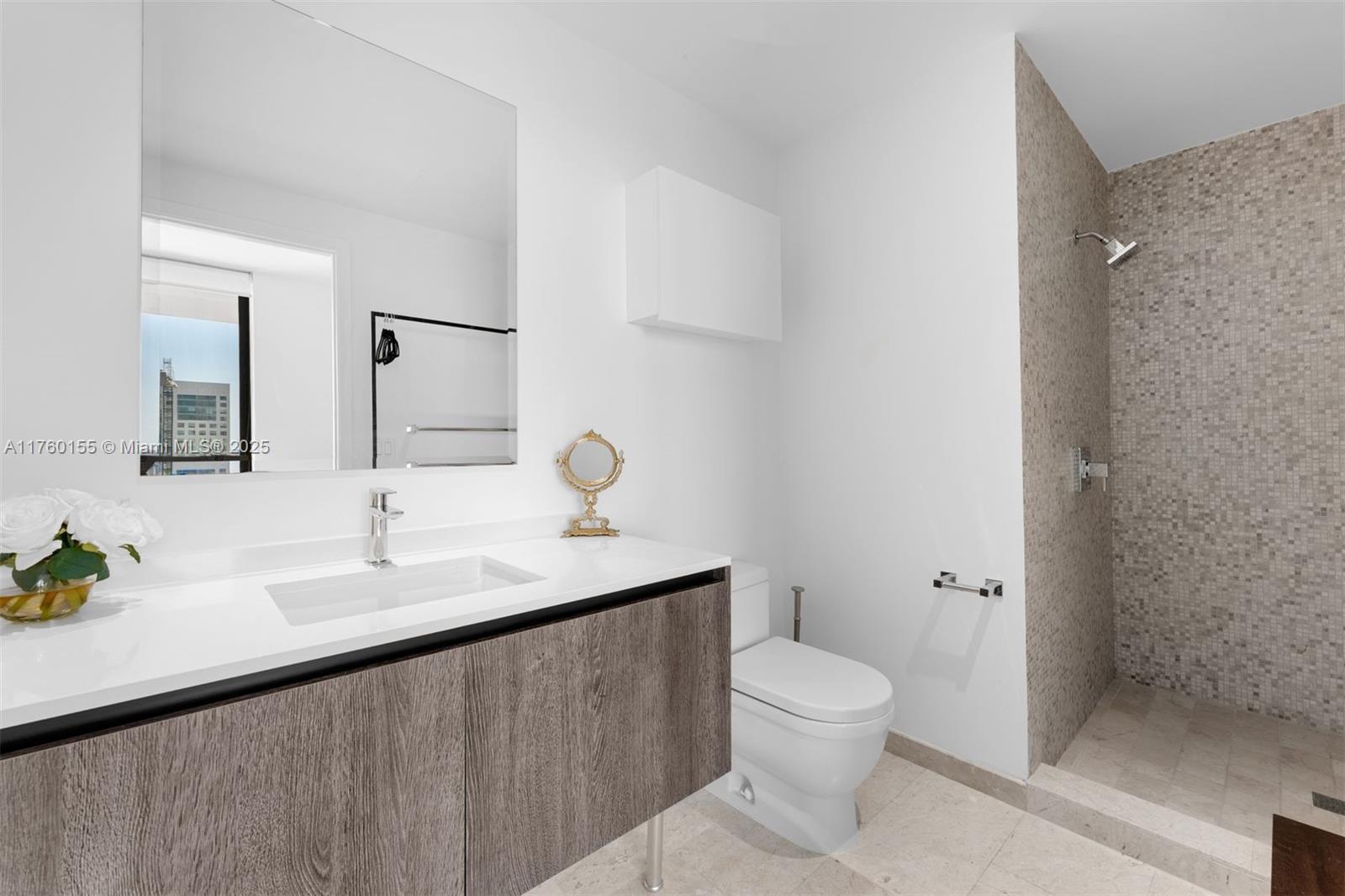 68 Southeast 6th Street, Unit 1404 Miami, FL 33131 - Photo 17 of 26 a bathroom with a toilet sink and mirror