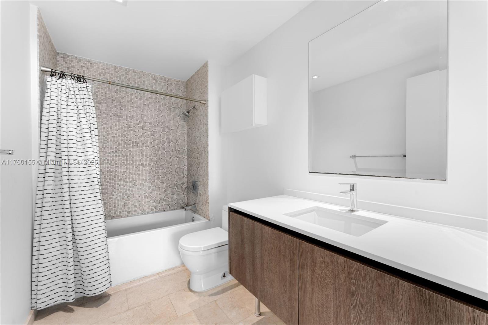 68 Southeast 6th Street, Unit 1404 Miami, FL 33131 - Photo 19 of 26 a bathroom with a sink a toilet and shower