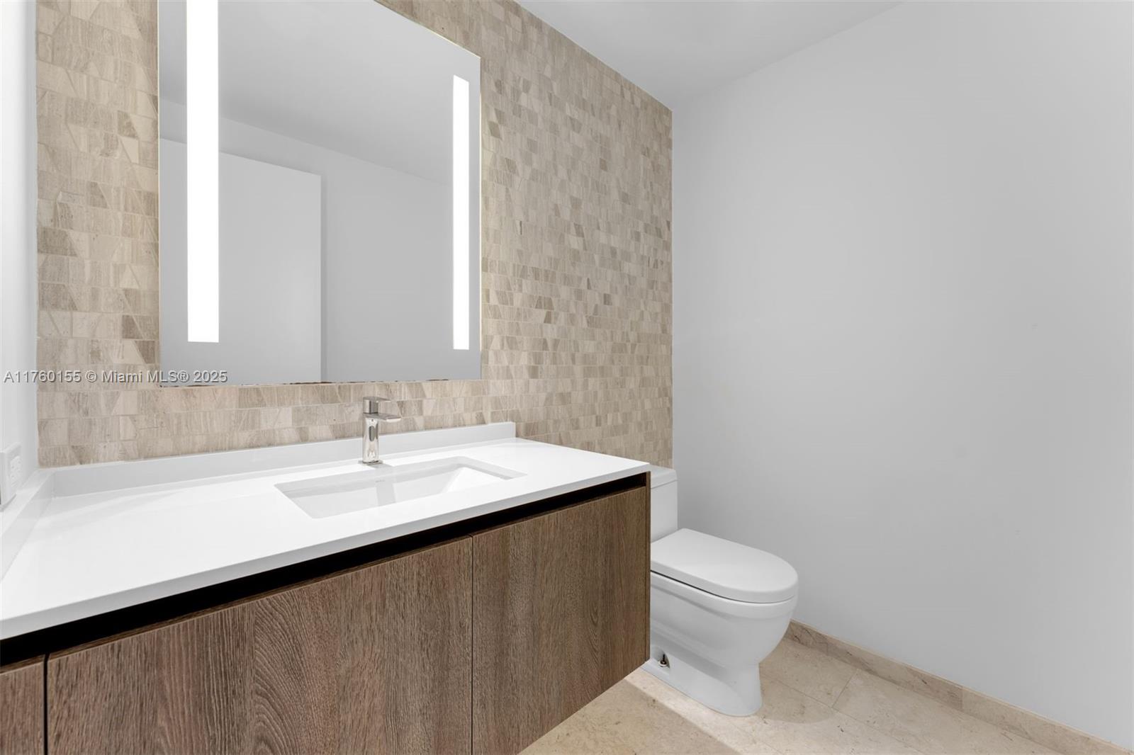 68 Southeast 6th Street, Unit 1404 Miami, FL 33131 - Photo 21 of 26 a bathroom with a sink a toilet and mirror