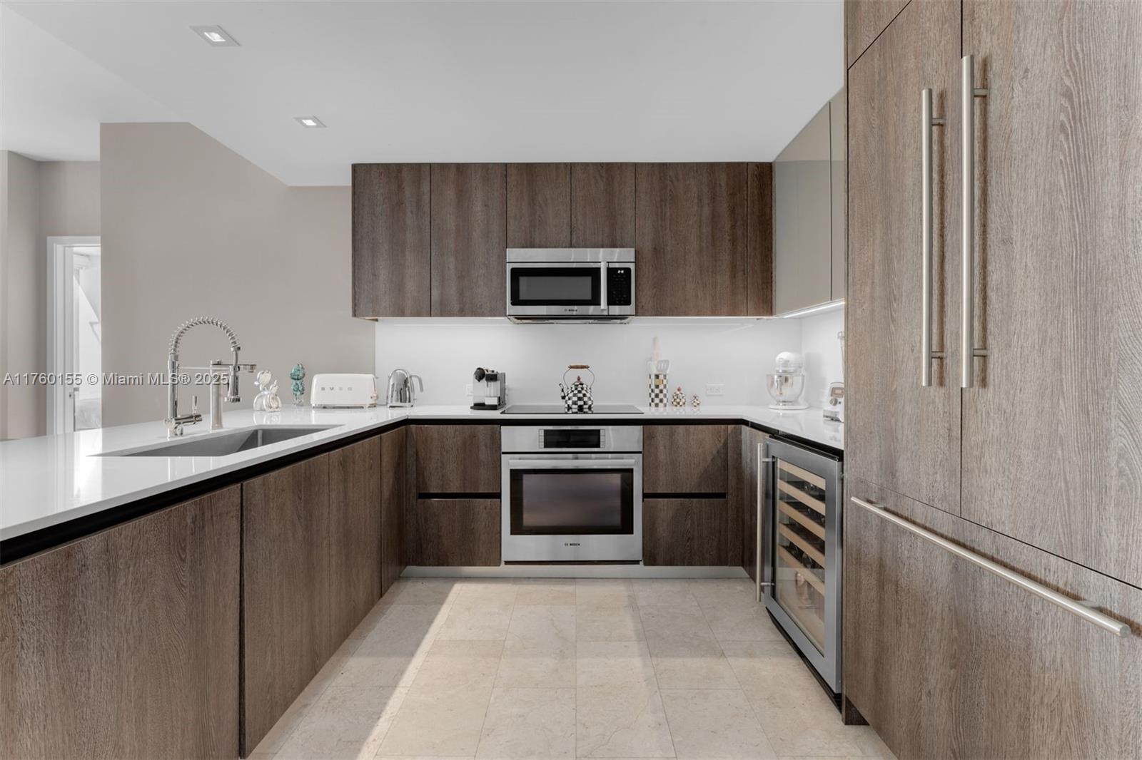 68 Southeast 6th Street, Unit 1404 Miami, FL 33131 - Photo 4 of 26 a kitchen with a sink and a stove top oven